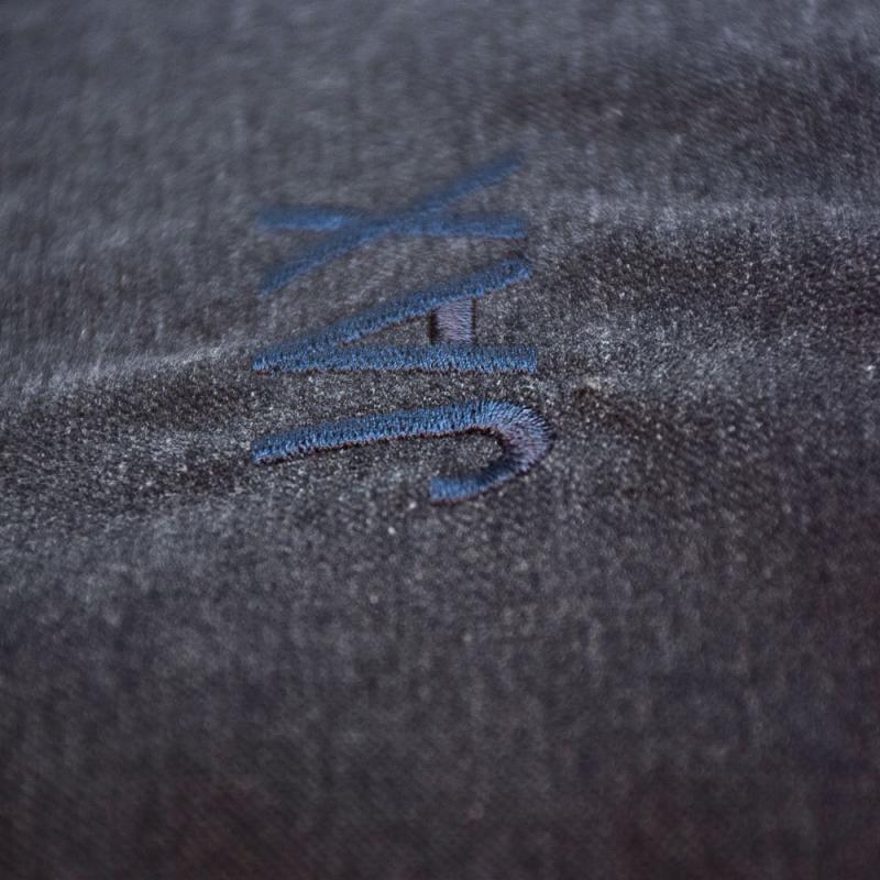 Närbild på mörkgrå bäddyna till katt eller hund med namnet Jax graverat i blått.