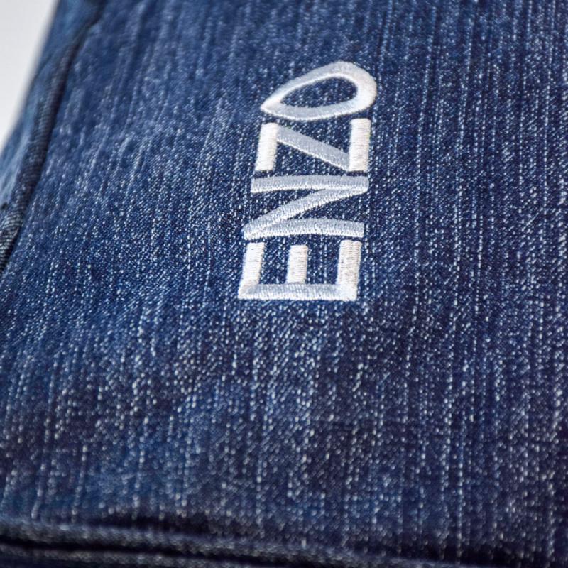 Närbild på bäddyna för hund och katt i denim med namnet Enzo graverat i vitt.