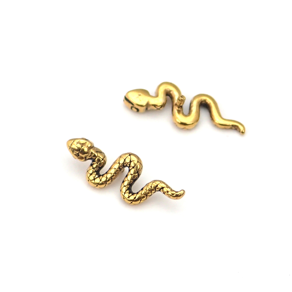 Piercingsmycke. En guldig orm som skruvas på invändigt gängade stavar.