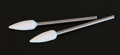 Poler- slipkon, grov men inte hård. 2 st. vita. Slipkorn inbakade i en silikon kon.