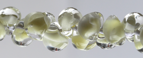 Glasdroppar i en "strand" om ca 25 st. Gul-vit-klar