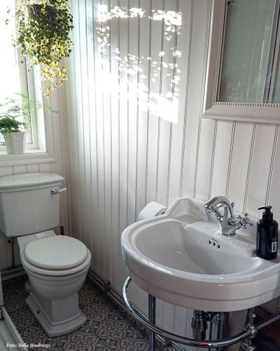 Lantligt badrum med pärlspont och ovalt tvättställ - gammaldags stil - klassisk inredning - sekelskifte - retro
