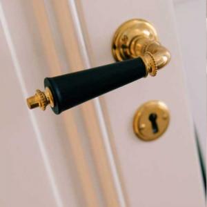 Time period 1880 - 1910. Classic door handle in untreated brass with black wooden grip