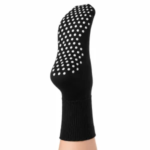 Svart 2GO Non Slip halksocka visad underifrån på fot, med vita halkskyddande silikonprickar över fotsulan.