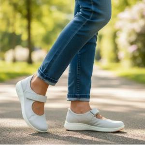 Miljöbild på en person som går på en parkväg iklädd ljusgrå Jomos Allegra D 2020 komfortskor i färgen Cloud och blå jeans.