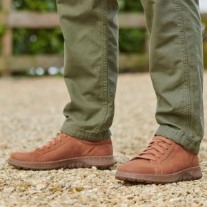 Brun Josef Seibel Jaron 01 herrsneaker i nubuckläder sedd från sidan, med melerad gummisula, ljusa sömmar, klassisk snörning och bruna skosnören på en person med gröna cargobyxor.