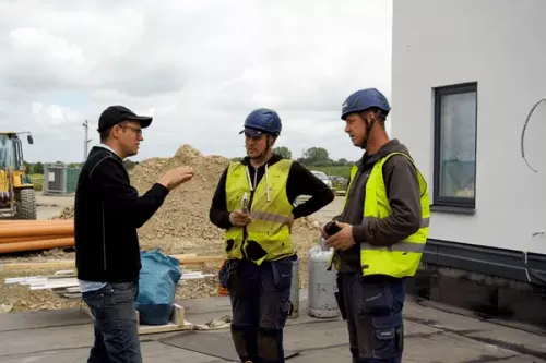 Sollex diskuterar hur takpapp skärs på byggarbetsplats i Burlöv med Takmontören