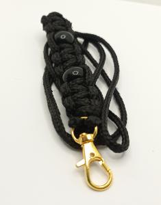 Visselpipsband i svart paracord, dekorerat med svarta pärlor.