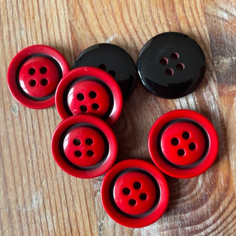 Röd knapp med svart dekor