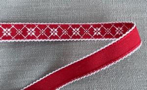 Textilband i rött med vita stjärnor i rutmönster och vit uddkant