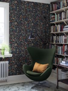 Tapet HERBARIUM, Stig Lindbergs lekfulla blommönster i brända toner på mörkblå bottenfärg