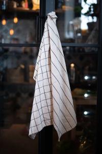 Kökshandduk Axel, i återvunnet material med vävda rutor i svart och beige.