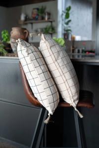 Kuddfodral Axel med tofsar, återvunnet material, vävda rutor i kastanje brun och beige.