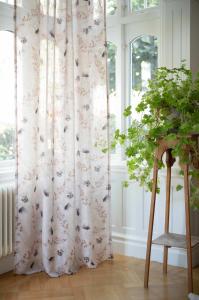 Gardin NOUR med vallmo och gräsvippor på sandfärgad botten