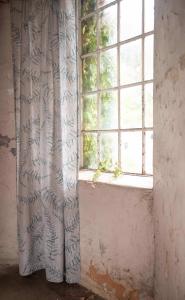 Gardin ELLIOT med stora ormbunksliknande gråblå blad på linnefärgad botten