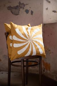 Kuddfodral SPIN med en broderad vindsnurra i beige, gul botten