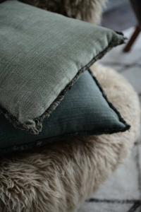 Kuddfodral DANNY, enfärgad med struktur och en kort frans runt om i mörkgrönt