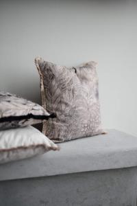 Kuddfodral FARAH med bladmönster i beigebruna toner på linnefärgad botten