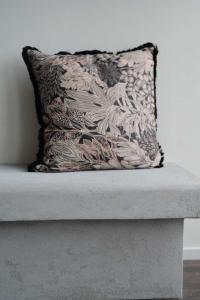 Kuddfodral FARAH med bladmönster i beigebruna toner på svart botten