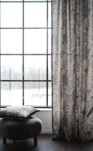 Gardin FARAH med bladmönster i beigebruna toner på svart botten