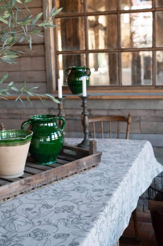 Duk ELLIE med ett snirklande fantasifullt bladmönster i grönt på beige botten