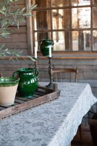 Duk ELLIE med ett snirklande fantasifullt bladmönster i grönt på beige botten