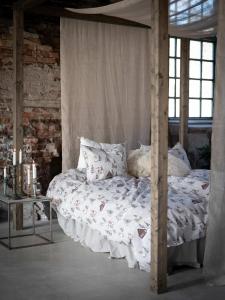 Bäddset HARALD med tomtar i bruna luvor, granar och små hus på linnefärgad botten