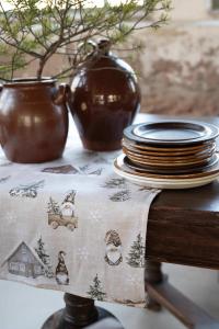 Bordslöpare HARALD med tomtar i bruna luvor, granar och små hus på linnefärgad botten
