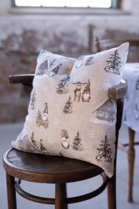 Kuddfodral HARALD med tomtar i bruna luvor, granar och små hus på linnefärgad botten