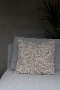 Kuddfodral INSE med klippta remsor i ett virrvarr mönster, sandfärgad