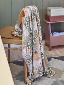 Pläd ÅSGRÄND med hundar och katter i lek bland små hus, grön bottenfärg