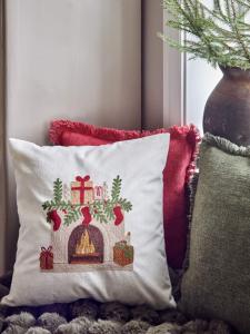 Kuddfodral BRASAN med broderad eldstad och paket och strumpor på spiskransen
