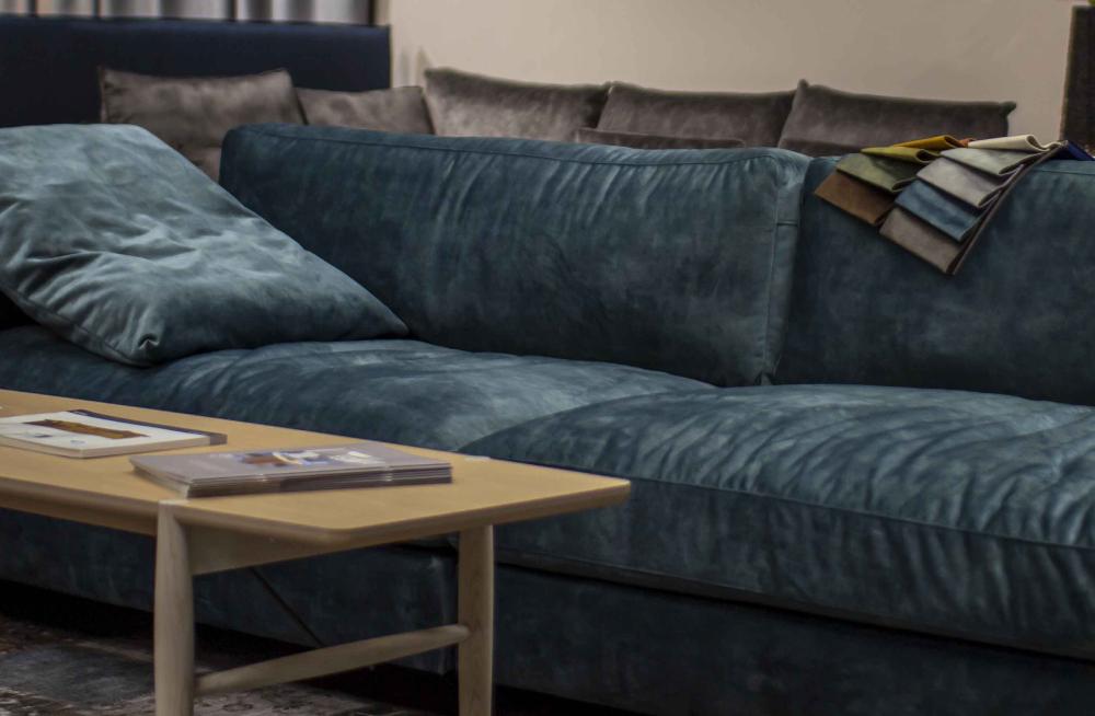 Bild på en blå sammetssoffa och ett soffbord i ljus ek, Produkter från Växthuset i Eskilstuna