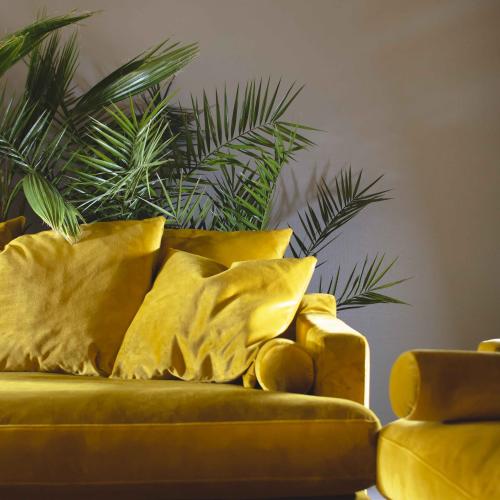 Bild på en gul soffa med gröna växter, produkter från Växthuset i Eskilstuna