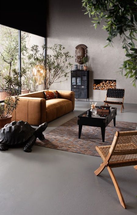 Modern inredning i mörka träslag, rotting och konjaksfärgat läder.